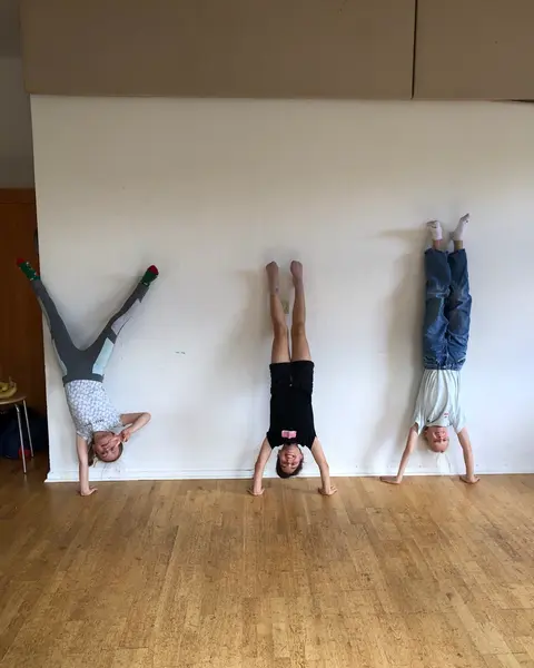 Heldentraining: Drei Heldinnen im Handstand an der Wand