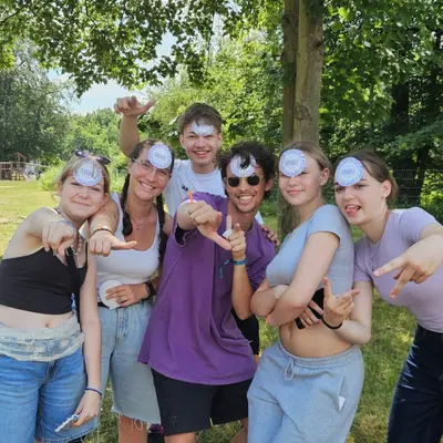Teenagers and a trainer goofing around with LevelUp stickers stuck to their foreheads