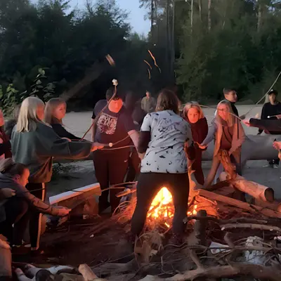 The class and their trainers sitting around the campfire in the evening